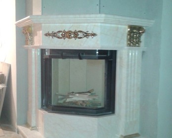 Угловой мраморный портал с декоративными элементами из латуни в коттедже