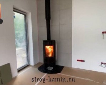Дровяная печь Астов R1.0 с дымоходом Феникс, в углу гостиной загородного дома - современная и греет Дровяная печь Астов R1.0 с дымоходом Феникс, в углу гостиной загородного дома - современная и греет